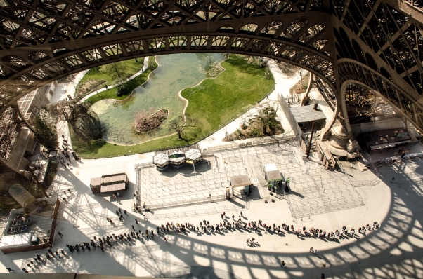 Visitors queue under Eiffel Tower for entry to top floor